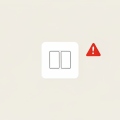 A white electrical outlet with two small blank buttons and a red warning triangle beside it