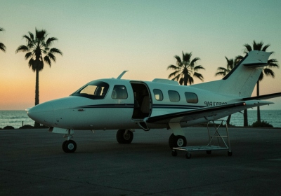 A small air-ambulance plane on a remote coastal airstrip at dusk, ready for a medical evacuation