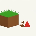 A green grass-topped cube block beside a broken jigsaw puzzle piece and a red warning triangle