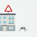 An apartment building with a blank yard sign, a set of keys, and a red warning triangle above it