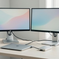 A USB-C docking station on a desk connected to two 4K monitors and a laptop