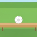 A single soccer ball resting on an empty substitutes' bench beside a green pitch