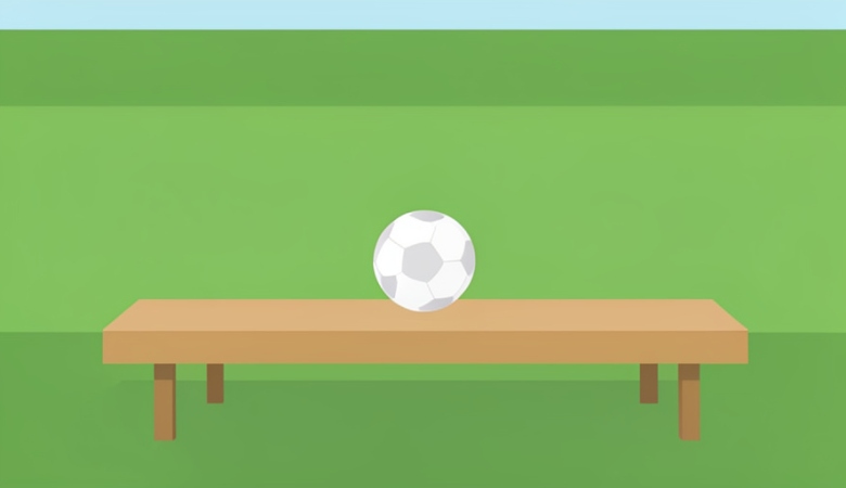 A single soccer ball resting on an empty substitutes' bench beside a green pitch